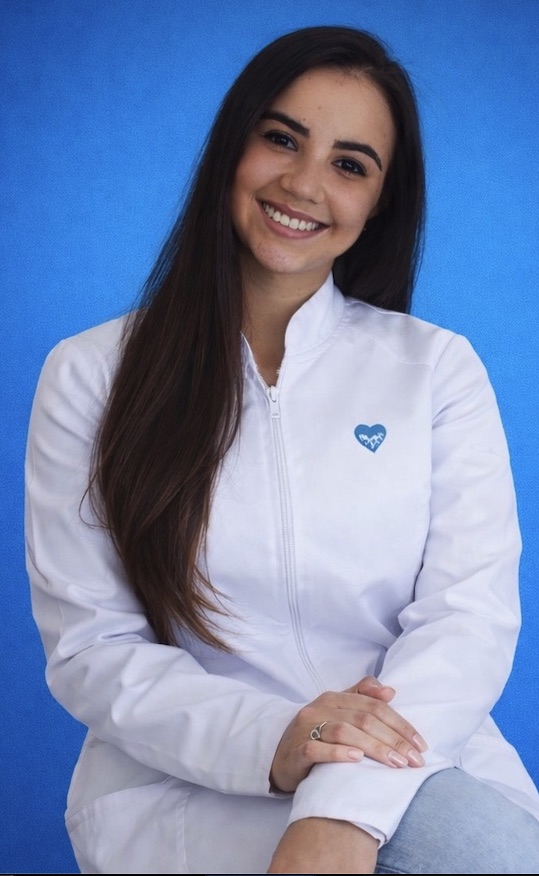 Dra. Brenda Rodrigues, cirurgiã-dentista, sorrindo de jaleco branco